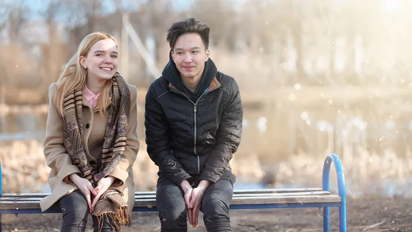 Un par de jóvenes se conocieron en el parque. Los amantes están sentados en un — Foto de Stock