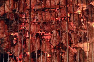 Barbekü charco üzerinde yemek pişirmek için bir ızgara kıyılmış et dilimleri