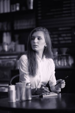 Bir kız bir kafede kahve içiyor. Bir kadın kahvaltı yapıyor