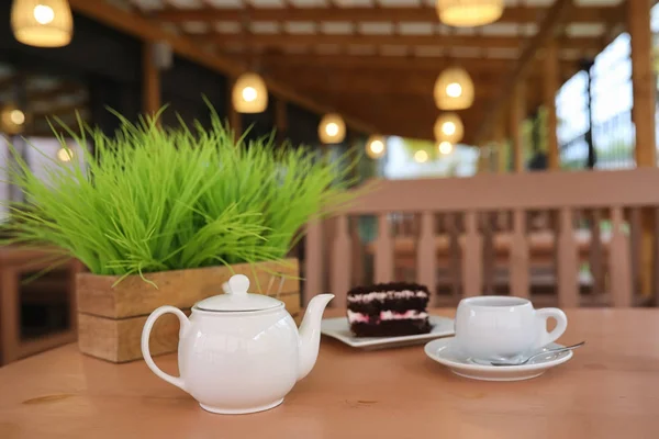Wasserkocher mit Getränk und Dessert in einem Straßencafé. Tee im Korb — Stockfoto