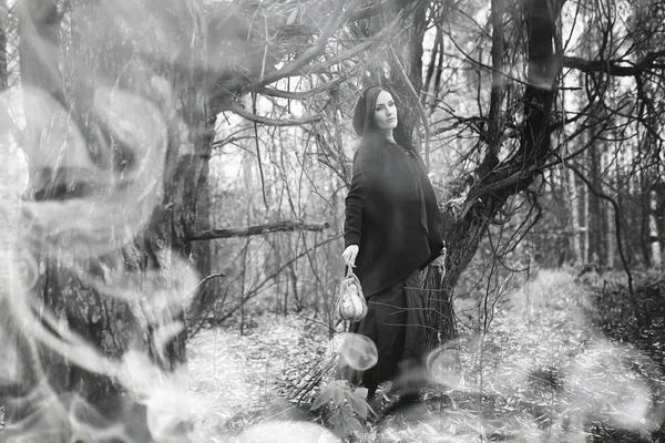 Woman in a witch suit in a dense forest — Stock Photo, Image