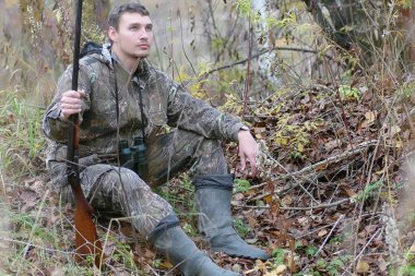 Kamuflaj ve bahar hun üzerinde orman Kuşağı'nda silahlı adam