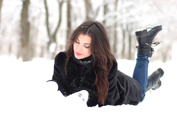 Μια νεαρή γυναίκα με τα πόδια σε ένα χειμερινό πάρκο — Φωτογραφία Αρχείου