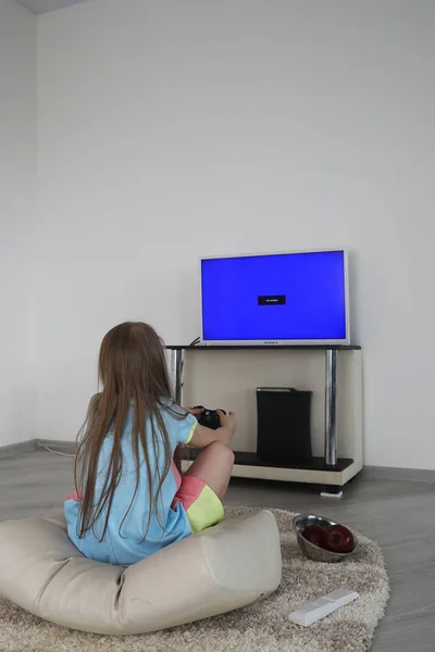 Młoda dziewczyna gry przed telewizorem — Zdjęcie stockowe
