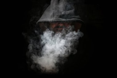 Adam siyah kukuleta ve duman