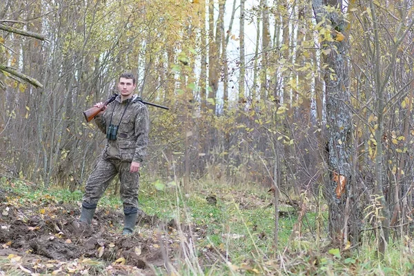 Hombre en camuflaje y con armas en un cinturón forestal en un hun de primavera — Foto de Stock