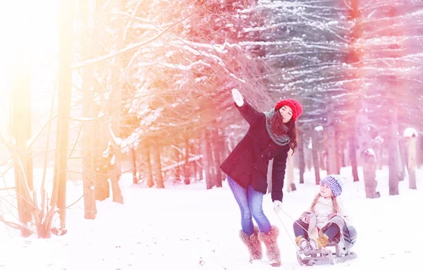 Een sprookje van de winter, een jonge moeder en haar dochter rit een slee — Stockfoto