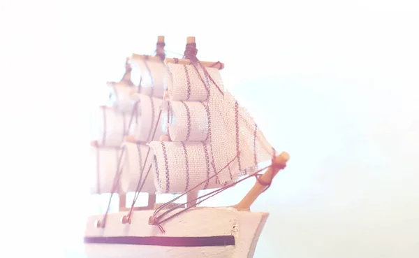 Old wooden ship with sails and masts toy on a stand. Vintage and