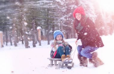 Bir kış masal, genç bir anne ve kızı bir kızak sürmek