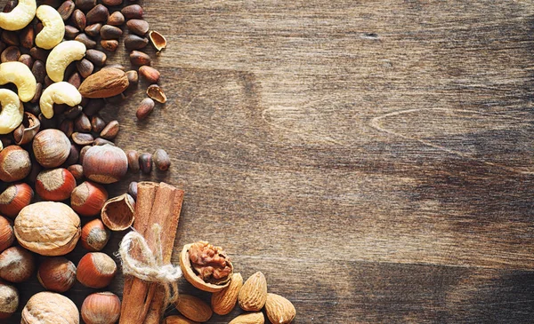 Verschiedene Nüsse auf einem Holztisch. Zeder, Cashew, Haselnuss, Walnuss — Stockfoto