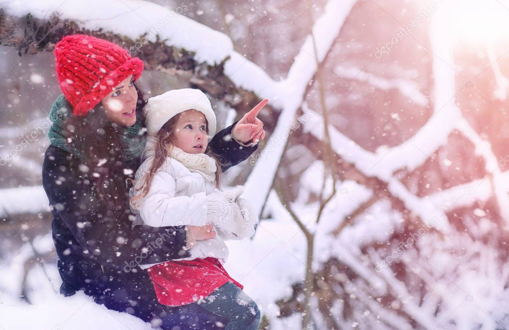 A winter fairy tale, a young mother and her daughter ride a sled