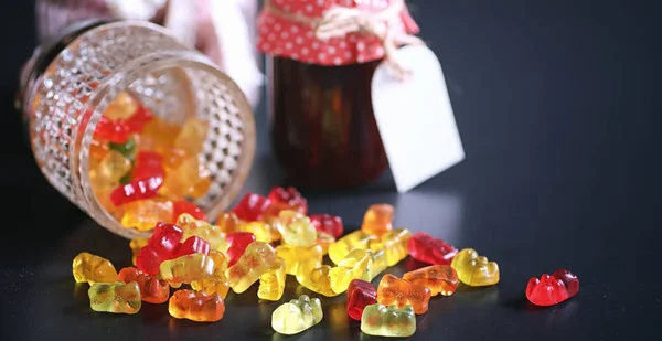 Marmelade dans un vase sur la table. Bonbons dans un bol sur une ba noire — Photo