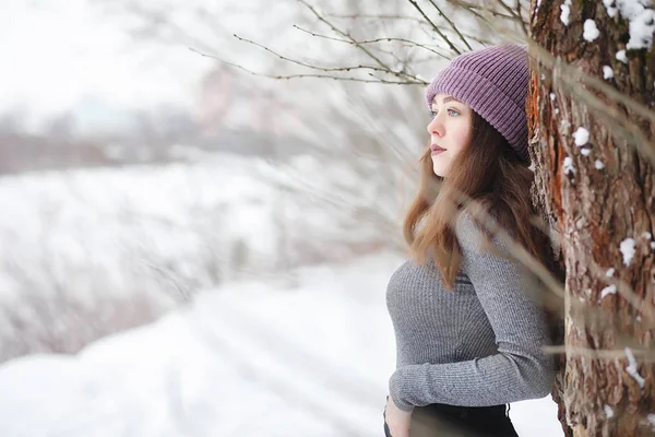 Ein junges Mädchen in einem Winterpark bei einem Spaziergang. Weihnachtsferien in t — Stockfoto