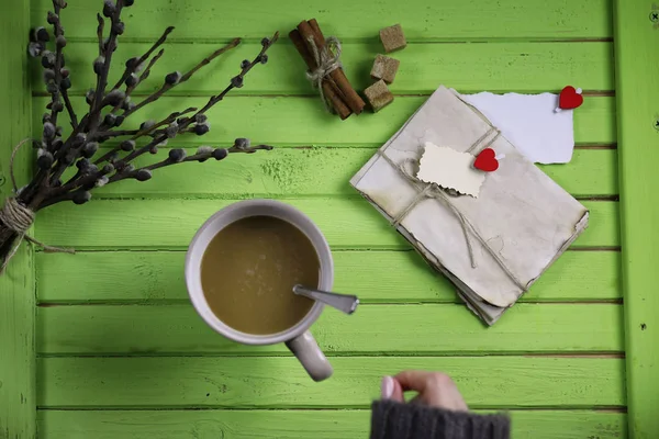 Girl drinking hot coffee and looks presented valentines — Stock Photo, Image