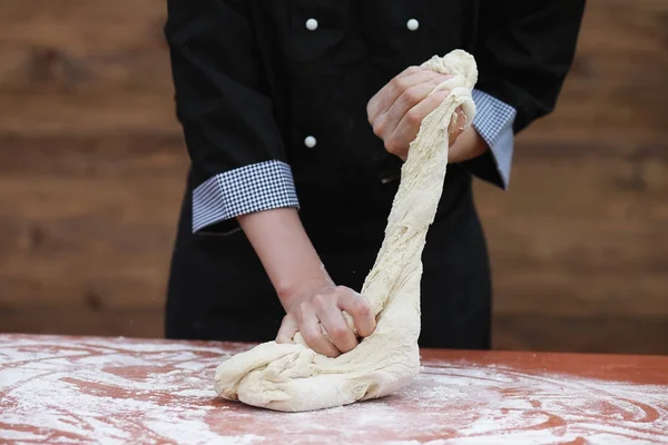 De kok maakt meel voor het bakken op tafel — Stockfoto