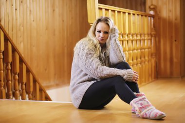 Genç bir kız bir kazaklı merdiveninde oturur