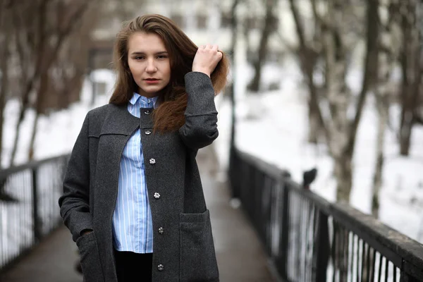 Giovane ragazza adulta in cappotto sulla strada — Foto Stock