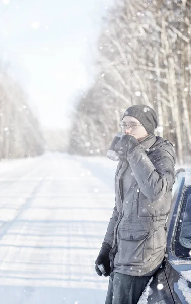 Man drink tea from mug outdoor on winter road — Stock Photo, Image