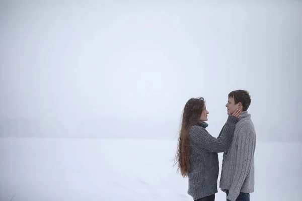 Par de amantes em uma tarde de inverno de data em uma nevasca de neve — Fotografia de Stock