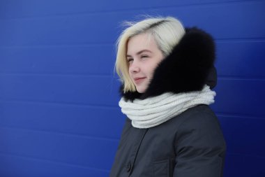 Genç güzel kız kış mavi duvar, bir yolda