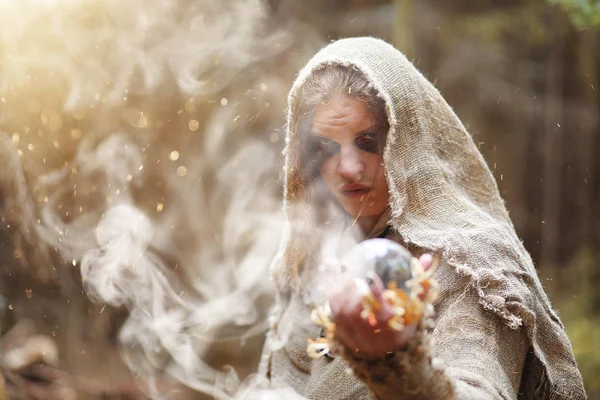 A man in a cassock spends a ritual in a dark forest — Stock Photo, Image