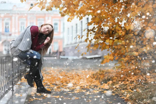 Девушка в парке в первый снегопад — стоковое фото