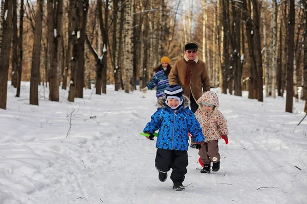 Niño corriendo en el parque de invierno y divertirse con la familia — Foto de Stock