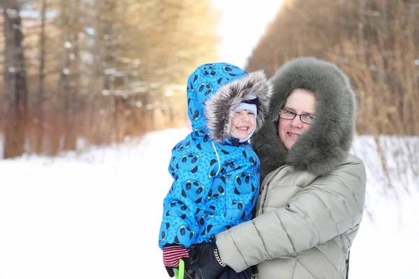 Rodič drží dítě na rukou v zimním parku — Stock fotografie