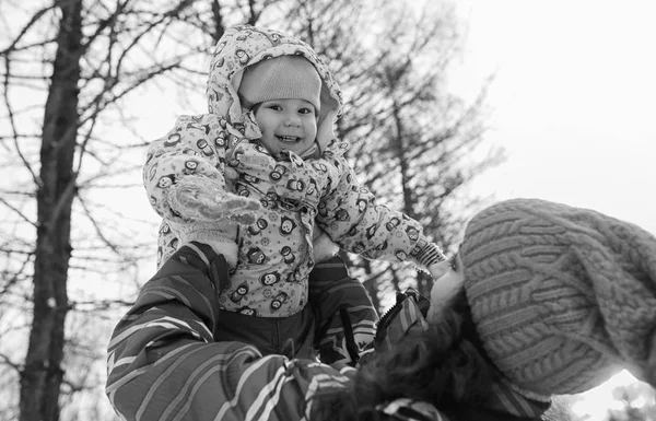 Svart och vitt foto av förälder som håller barn på händer på vintern p — Stockfoto