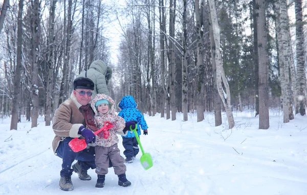 Famiglia con passeggiata per bambini nel parco invernale innevato — Foto Stock
