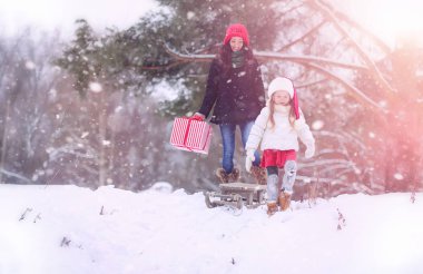Bir kış masal, genç bir anne ve kızı bir kızak sürmek