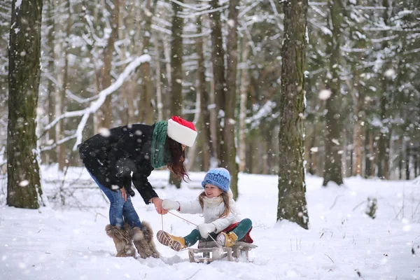 Um conto de fadas de inverno, uma jovem mãe e sua filha montam um trenó — Fotografia de Stock