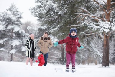 Çocuklu genç aile kış parkta yürüyüş. Winte