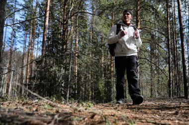 Bir turist bir çam ormanı ile bir sırt çantası içinde bir adamdır. A tr hiking