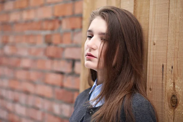 Молодая красивая девушка возле стены из красного кирпича — стоковое фото