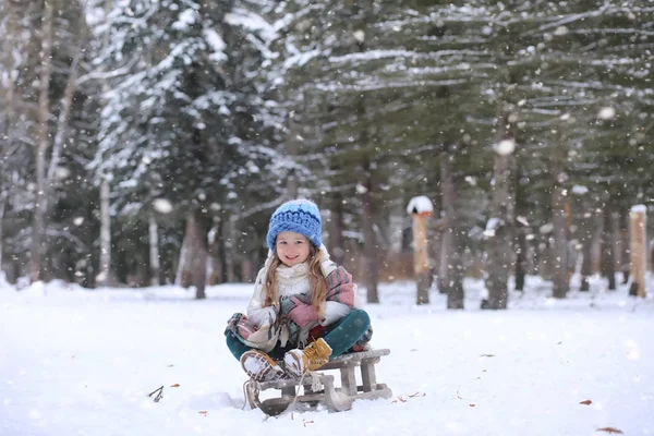 Ein Wintermärchen, eine junge Mutter und ihre Tochter fahren Schlitten — Stockfoto