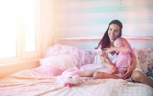 Jovem lê um livro Jovem com uma filha estão sentados o — Fotografia de Stock