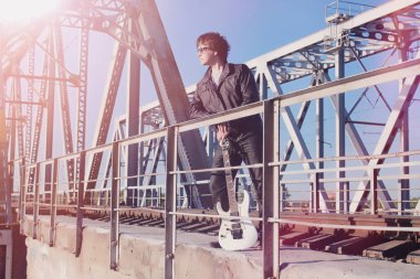 Bir elektro gitar demiryolu üzerinde olan bir adam. Bir Le bir müzisyen