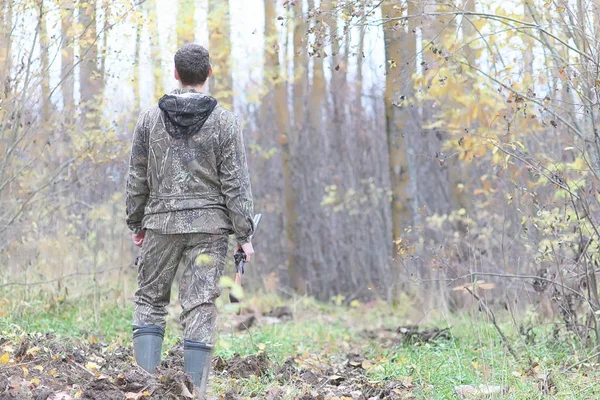 Hombre en camuflaje y con armas en un cinturón forestal en un hun de primavera — Foto de Stock