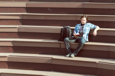 Dışarıda tek başına oturan bir adam var.