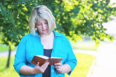 kadınla çimenlerin üzerinde kitapla Park