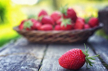 Hasır plaka ahşap arka plan üzerinde çilek