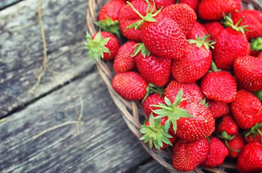 Hasır plaka ahşap arka plan üzerinde çilek