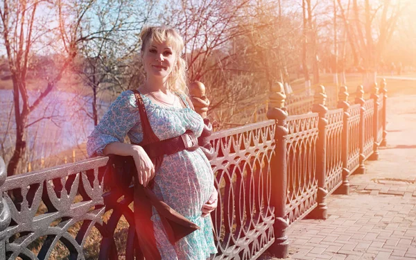 Gravid flicka på en promenad i parken. Flicka med en mage i ci — Stockfoto