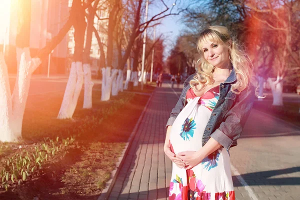 Zwanger meisje op een wandeling in het park. Meisje met een buik in de ci — Stockfoto