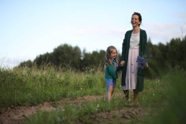 Anne ve kızı yolda yürüyor.