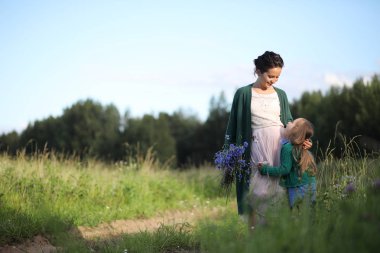 Anne ve kızı yolda yürüyor.