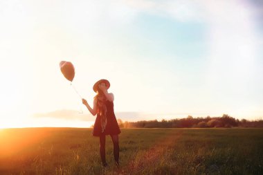 Parkta bir yürüyüş üzerinde şapkalı bir kız. Bir kızla bir sepet yürüyüş