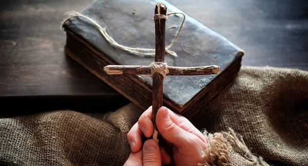 Livro velho religioso em uma mesa de madeira. Uma cruz religiosa amarrado sagacidade — Fotografia de Stock