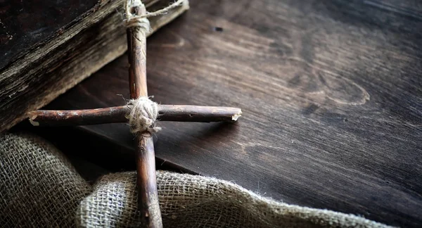 Livro velho religioso em uma mesa de madeira. Uma cruz religiosa amarrado sagacidade — Fotografia de Stock